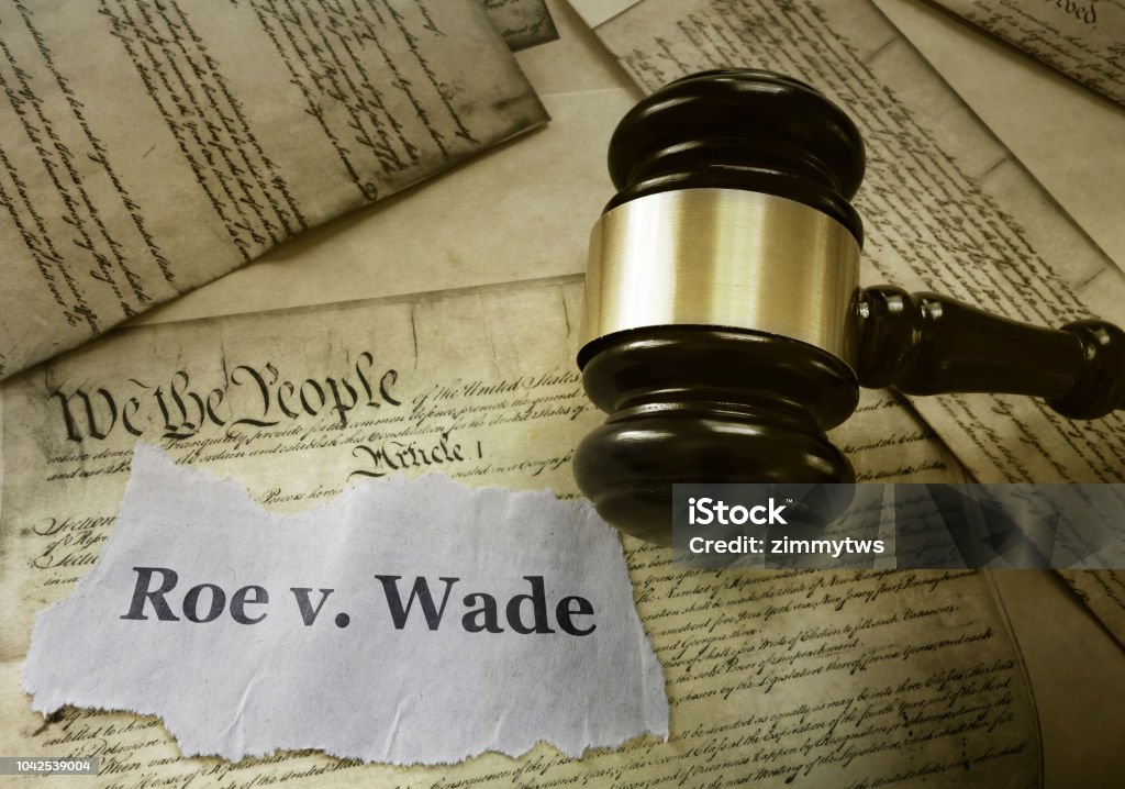 Roe v Wade news headline with gavel on a copy of the United States Constitution
